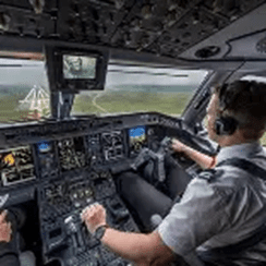 Pilot operating an aircraft in the cockpit, focused on landing with controls and digital displays visible. Relevant for aviation safety and operations discussions.