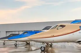 Three sleek business jets in varying colors—gold, blue, and black—parked on a reflective surface, showcasing luxury and modern aviation design.